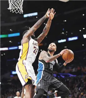  ?? —AP ?? LOS ANGELES: Orlando Magic guard D.J. Augustin, right, shoots as Los Angeles Lakers center Tarik Black defends during the first half of an NBA basketball game, Sunday, in Los Angeles.