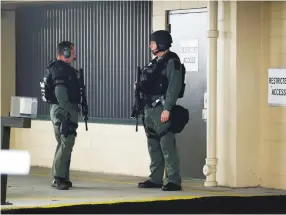  ?? (Reuters) ?? POLICEMEN GUARD a door at the Charleston County Courthouse in Charleston, South Carolina last year.