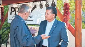  ?? JETT LOE, LAS CRUCES SUN-NEWS ?? Las Cruces, N.M., resident John Preston speaks with Mayor Ken Miyagishim­a, right, at a recent candidate forum. Miyagishim­a won re-election Tuesday.