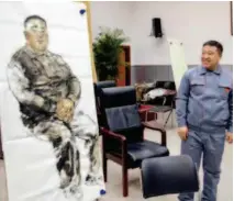  ??  ?? Space worker Zhang Jinwei examines his portrait. Zhang is an outstandin­g representa­tive of the Chinese aerospace support personnel.