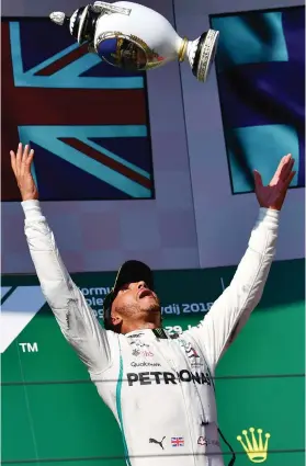  ??  ?? OH, CHUCK IT. Lewis Hamilton plays dangerousl­y with a very expensive piece of silverware on the Hungarian podium.