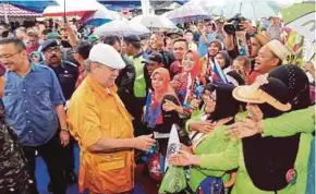  ?? PIC BY ZAIN AHMED ?? Sultan of Johor Sultan Ibrahim Sultan Iskandar meeting the people at Dataran Segamat yesterday. With him is Defence Minister Datuk Seri Hishammudd­in Hussein (left).