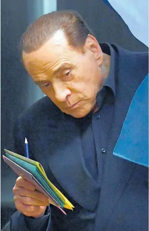  ??  ?? Former Italian leader Silvio Berlusconi voted in Milan and was confronted by a Fe e