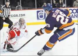  ?? Mary Altaffer The Associated Press ?? Islanders center Brock Nelson scores the winning goal past Red Wings goalie Petr Mrazek with 1:45 left in overtime of New York’s 7-6 victory Friday.