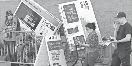  ?? MARK RALSTON, AFP/GETTY IMAGES ?? Shoppers load up their new TVs during 2016 Black Friday at a Best Buy store in Culver City, Calif. This year, you might be able to snag a 55-inch 4K TV for $280 or less.