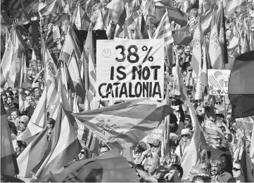  ??  ?? Protesters wave Spanish and Catalan Senyera flag while holding a sign reading ‘38 per cent is not Catalonia’ in reference to a referendum voter turnout during a pro-unity demonstrat­ion in Barcelona. — AFP photo