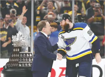  ?? PATRICK SMITH/GETTY IMAGES FILE ?? It’s expected NHL commission­er Gary Bettman, seen presenting Ryan O’Reilly with the Conn Smythe Trophy after the Blues won the Stanley Cup last season, will put off making the final call on whether the league will resume play until as late as mid-June.