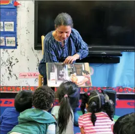  ?? ADRIANA ALBA — CHILDREN’S AID VIA THE ASSOCIATED PRESS ?? In this 2018 photo provided by Children’s Aid, Nina Crews, illustrato­r of “A Girl Like Me,” reads to children at an early childhood education center.