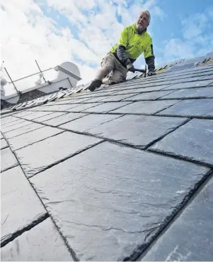  ?? PHOTO: GERARD O’BRIEN ?? One of many . . . John Meegan Roofing owner John Meegan adds another slate tile to the thousands he is putting on the roof of the old Dunedin Prison.