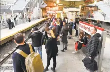  ?? Matthew Brown / Hearst Connecticu­t Media ?? Commuters wait on the platform as a Metro-North train arrives at the Stamford train station on Tuesday. A new Metro-North report is out, detailing the MTA's public strategic plan called “Way Ahead.”