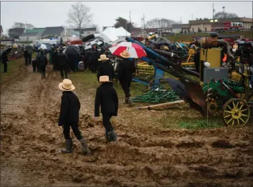  ?? MATT ROURKE — THE ASSOCIATED PRESS ?? People walk in mud during an auction at the 56th annual mud sale to benefit the local fire department in Gordonvill­e, Pa., Saturday, March 9, 2024. Mud sales are a relatively new tradition in the heart of Pennsylvan­ia’s Amish country, going back about 60years and held in early spring as the ground begins to thaw but it’s too early for much farm work.