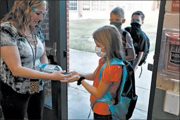  ?? LM OTERO/AP ?? Students use hand sanitizer before entering school Wednesday in Godley, Texas.