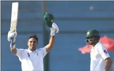  ?? — AFP photo ?? Abid (left) celebrates after scoring 150 runs next to captain Azhar Ali during the third day of the second test cricket match between Pakistan and Sri lanka at the National cricket Stadium in Karachi.