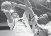  ?? Michael Ciaglo / Houston Chronicle ?? Bush’s Peter Byrd, left, tries to avoid the defense of Elkins’ Ansu Sesay on Friday night.