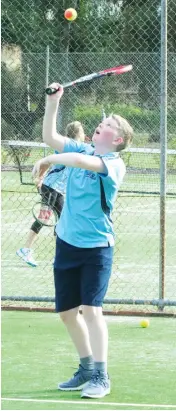  ??  ?? Darcy Height serves in Baw Baw junior tennis.