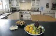  ?? Postmedia News ?? Granite is a favourite choice for new and renovated kitchens alike. A butcher block accent is a nice addition.