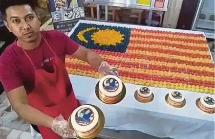  ?? PIC BY ZULIATY ZULKIFFLI ?? Baker Azrul Nizam Azali showing his Jalur Gemilang cream puffs and cakes bearing a picture of former prime minister Tunku Abdul Rahman Putra al-Haj in Yan yesterday.