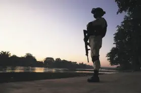  ?? Marco Ugarte / Associated Press ?? A Mexican National Guard soldier patrols near Ciudad Hidalgo on Jan. 20 along the bank of the Suchiate River, which forms the border with Guatemala.