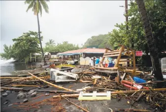  ?? Lionel Chamoiseau / AFP / Getty Images ?? Residents sort through debris on the French Caribbean island of Martinique, after it was hit by Hurricane Maria. The neighborin­g island of Guadeloupe reported at least one death.