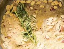  ?? DAVID MALOSH/THE NEW YORK TIMES PHOTOS ?? Sliced almonds cook in preparatio­n for the pasta dish. Sprigs of rosemary add an herby earthiness.