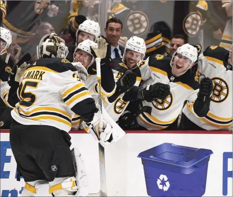  ?? RICH LAM — THE CANADIAN PRESS VIA AP ?? Boston Bruins goalie Linus Ullmark, left, celebrates his empty-net goal against the Vancouver Canucks during the third period Saturday in Vancouver. British Columbia.