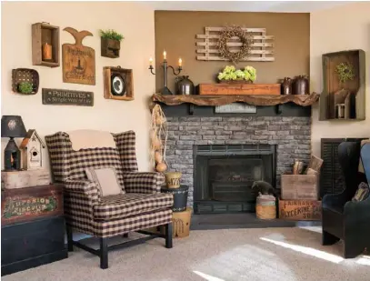  ??  ?? Left: To update the brick hearth in the living room, the couple modified the fireplace with an old-fashioned black mantel, a removable electric log insert and an antique fireplace screen. The woodslat piece above the mantel is part of a vintage creeper that would have been used by a mechanic to slide underneath a vehicle. A buffalo-check wing chair, stacked boxes in lieu of a side table, and shadow boxes combine for a cozy fireside sitting area.
Below: In the living room, sunlight filters through the gauze fabric curtains, and the color black unifies a lover’sknot sofa, buffalo-check love seat and accent furniture. An antique shutter above the windows, a bushel basket lampshade and a make-do funnel light impart whimsy.