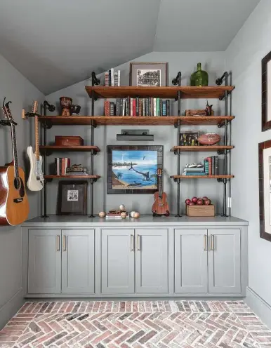  ?? Michael Hunter ?? In this study, Kiley Jackson and Aileen Warren of Jackson Warren Interiors mixed books with mementoes that show the homeowner’s hobbies: fishing, sports, music and travel.