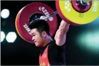  ?? XINHUA ?? Shi Zhiyong, representi­ng Zhejiang province, completes a lift en route to breaking national records in the snatch (170 kg) and total (365 kg) at the 14th National Games in Xi’an on Sept 22.