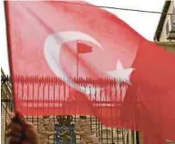  ?? AGENCY PIX ?? A policeman trying to get his dog to let go of a man after riots broke out during a rally at the Turkish consulate in Rotterdam yesterday. (Left) A Turkish flag flying on the roof of the Dutch consulate in Istanbul after protesters broke into the...