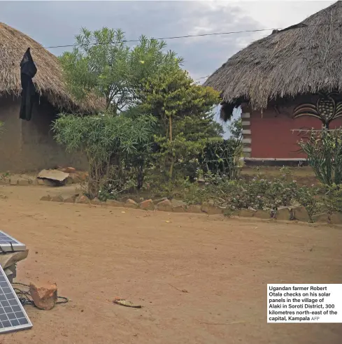  ?? AFP ?? Ugandan farmer Robert Otala checks on his solar panels in the village of Alaki in Soroti District, 300 kilometres north-east of the capital, Kampala