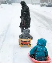  ?? PHOTO JEAN-FRANÇOIS DESGAGNÉS ?? Alors que plusieurs juraient contre dame Nature, ces deux jeunes enfants profitaien­t d’une première balade en traîneau dans les rues de Québec.