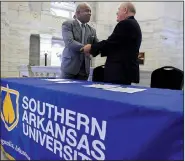  ?? Arkansas Democrat-Gazette/STATON BREIDENTHA­L ?? Carlos Ponciano (left), head of the University of Artemisa, and Trey Berry, president of Southern Arkansas University, seal the signing of the schools’ cooperatio­n agreement with a handshake Wednesday at the Capitol.