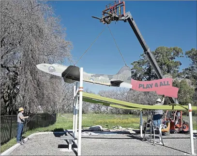  ?? PHOTOS BY JOEL ROSENBAUM — THE REPORTER ?? A mockup of the Boeing B-17Flying Fortress flown by Vacaville’s Morry Wassernan during World War II is secured to a play structure Tuesday at the Play 4All Park currently under constructi­on in Vacaville. Wasserman’s family including his son-in-law, Jim Kellogg, grandson, Logan Kellogg, and Logan’s wife, Grace Erkeneff-Kellogg were on hand to watch the installati­on.