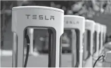  ?? LUCY NICHOLSON • REUTERS ?? A Tesla SuperCharg­er station is seen in Los Angeles on July 9. Tesla Inc’s shares rose even higher after the electric carmaker announced a five-for-one stock split.