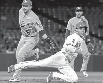  ?? Jayne Kamin-Oncea Getty Images ?? ANDRELTON SIMMONS of the Angels is tagged out by Jed Lowrie of the Athletics in a rundown.