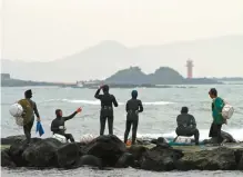  ?? Yonhap ?? A group of female divers prepares to go to work wearing bodysuits and carrying their floats on Jeju Island.