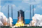 ?? CAI YANG/XINHUA VIA AP ?? A Long March-5 rocket carrying the Tianwen-1 Mars probe lifts off from the Wenchang Space Launch Center in southern China’s Hainan Province on Thursday.
