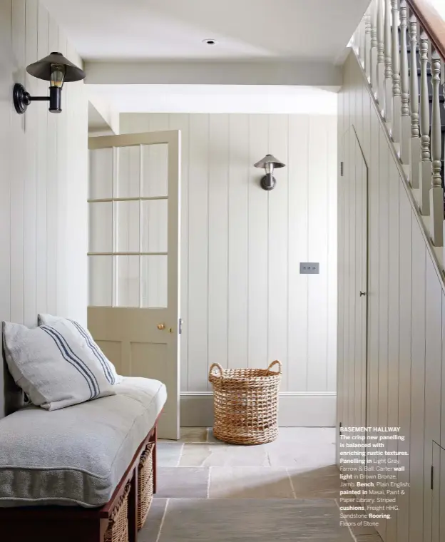  ??  ?? BASEMENT HALLWAY The crisp new panelling is balanced with enriching rustic textures.
Panelling in Light Gray, Farrow & Ball. Carter wall light in Brown Bronze, Jamb. Bench, Plain English; painted in Masai, Paint & Paper Library. Striped cushions, Freight HHG. Sandstone flooring,
Floors of Stone