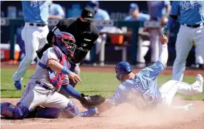  ?? AP Photo/Orlin Wagner ?? ■ Kansas City Royals Whit Merrifield (15) beats the tag by Texas Rangers catcher Jose Trevino, left, during the sixth inning Saturday at Kauffman Stadium in Kansas City, Mo.