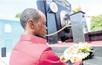  ?? RUDOLPH BROWN ?? Lionel Francis, whose child, Yetanya Francis, who was murdered in 2018, lays a wreath in commemorat­ion of children who have died under tragic circumstan­ces at the Secret Gardens Monument in downtown Kingston yesterday.