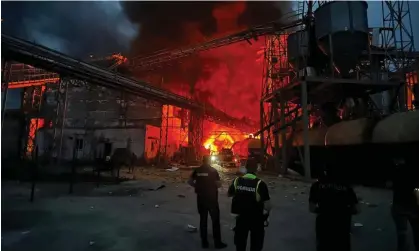  ?? Photograph: Ukrainian Presidenti­al Chief of/AFP/Getty Images ?? Ukrainian law enforcemen­t officers stand next to the burning industrial facility following a missile strike in the village of Hoholeve, Poltava region amid Russia’s war in Ukraine.