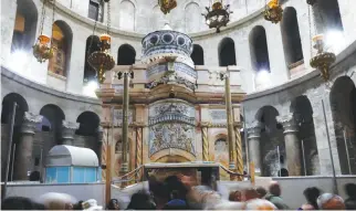  ??  ?? VISITORS STAND near the Edicule housing the tomb where Jesus’ body was anointed and buried, at the completion of months of restoratio­n work at the Church of the Holy Sepulchre in Jerusalem’s Old City, on March 20.