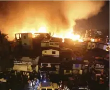  ?? LINUS ESCANDOR II/THE ASSOCIATED PRESS ?? New Year’s fireworks sparked a fire that gutted 1,000 shanties in the poor neighbourh­ood of Tondo in Manila.