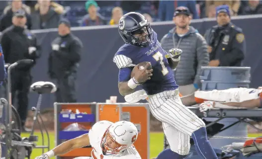  ?? JEFF ZELEVANSKY/GETTY IMAGES ?? Brandon Wimbush of Notre Dame tries to stay inbounds in front of Kyle Lawrence Strickland of Syracuse during their game at Yankee Stadium on Saturday in New York.