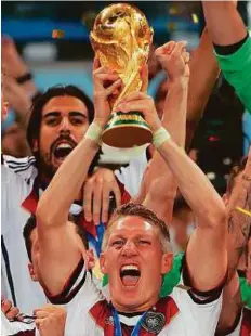  ?? Rex Features ?? Bastian Schweinste­iger lifts the World Cup trophy after Germany won the 2014 final against Argentina in Brazil.