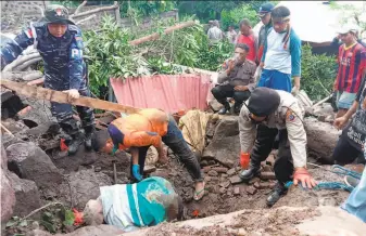  ?? Ricko Wawo / Associated Press ?? Rescuers search for victims on Lembata Island, Indonesia. Torrential rains in eastern Indonesia and neighborin­g East Timor have left a number of people dead or missing.