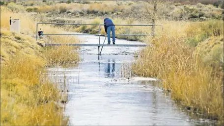  ?? Mark Boster Los Angeles Times ?? AN EMPLOYEE of the Department of Water and Power takes water readings on a tributary of the Owens River near Bishop, Calif.