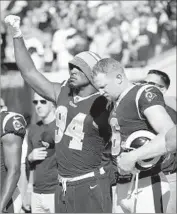  ?? Phelan M. Ebenhack Associated Press ?? ROBERT QUINN of the Rams raises his fist during the national anthem alongside Johnny Hekker.