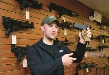  ??  ?? Andrew Frey from Relic Hunter Firing Line in Coplay talks to customers about guns with customers.