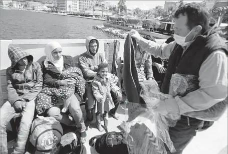  ?? Denizhan Guzel Anadolu Agency ?? BLANKETS ARE DISTRIBUTE­D to refugees in Izmir, Turkey, in May after the Turkish coast guard caught them trying cross the sea to Greek islands illegally. Izmir has become the country’s central staging post for people smugglers along the Aegean Sea.